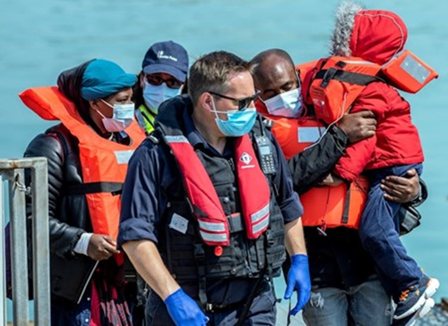 Border Force officials escorting migrants who arrived in Dover in April 2024 after crossing the Channel in a small boat. Sean Aidan Calderbank/Shutterstock
