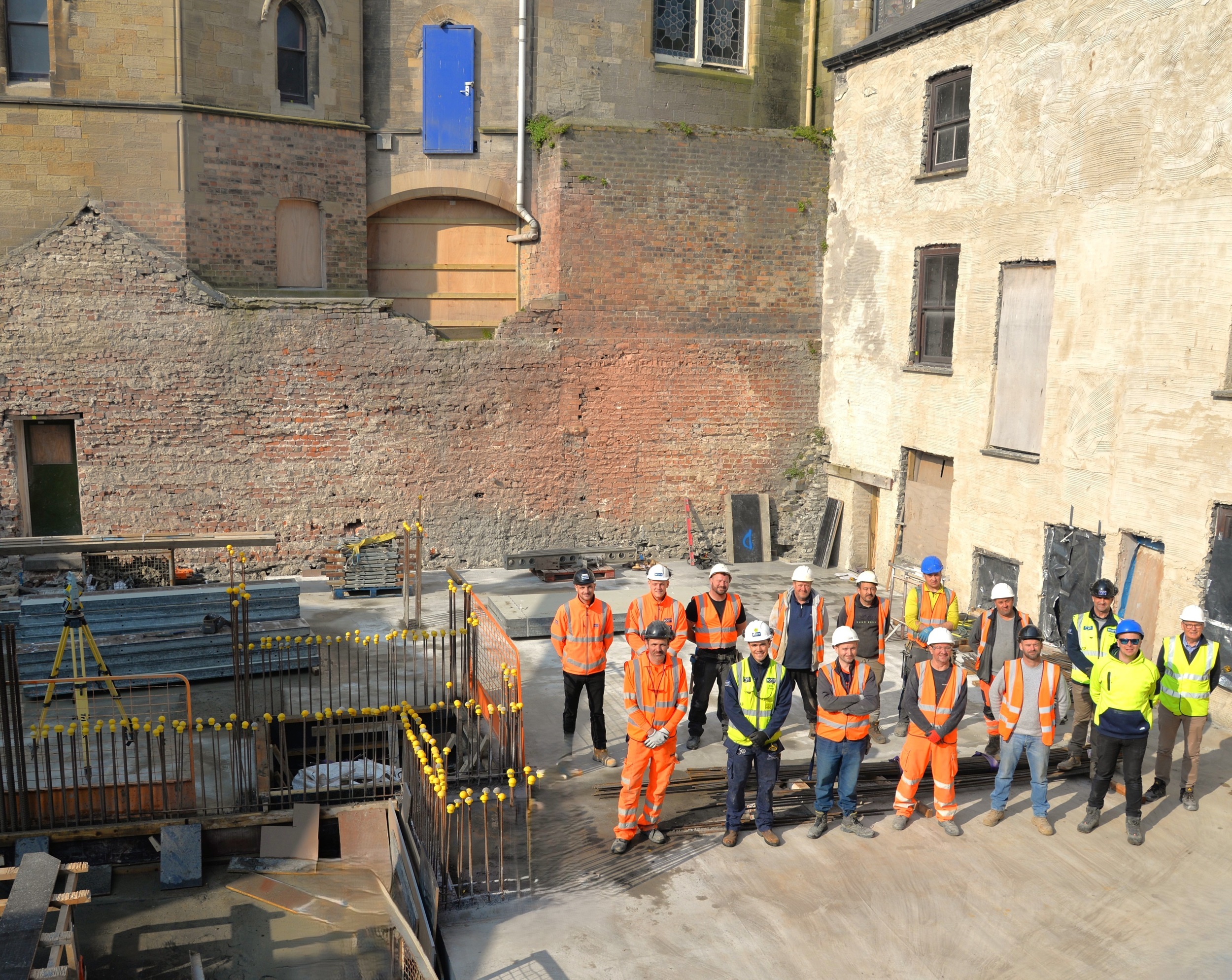 Aelodau o staff Andrew Scott Cyf, Prif Gontractwr Prosiect yr Hen Goleg, a’r is-gontractwr M&C Civils, yn nodi cwblhau slab concrit llawr gwaelod yr atriwm – Ebrill 2025.