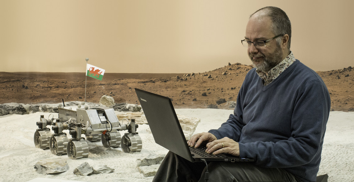 A lecturer working with a robot.