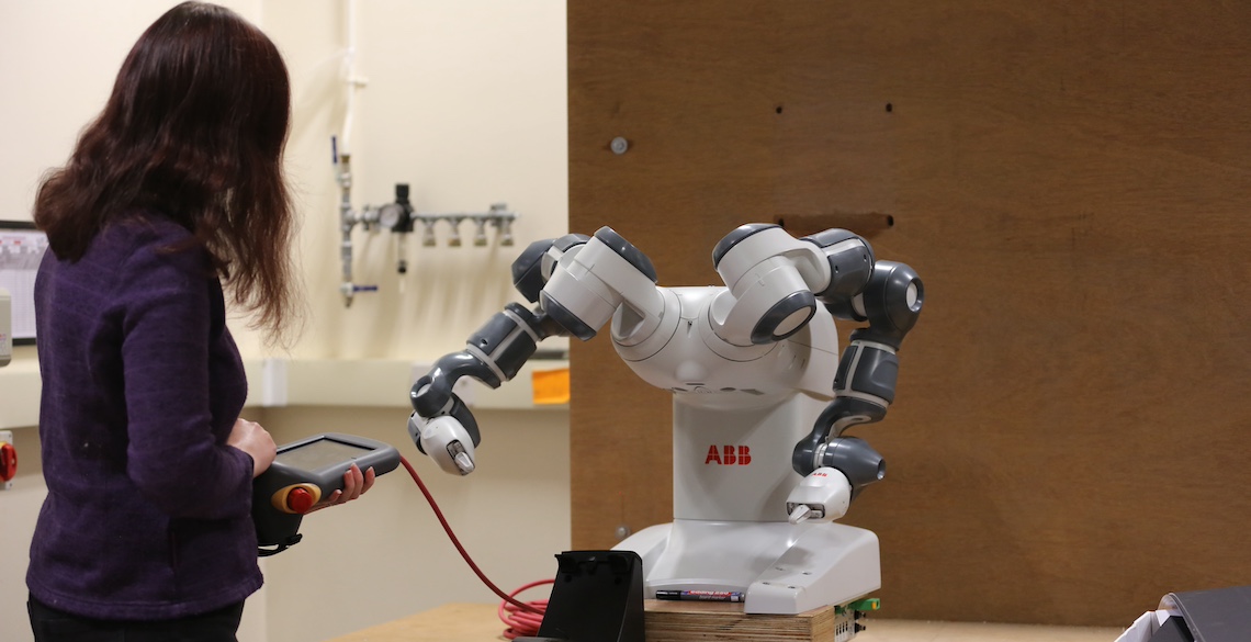 A researcher controlling a robot.