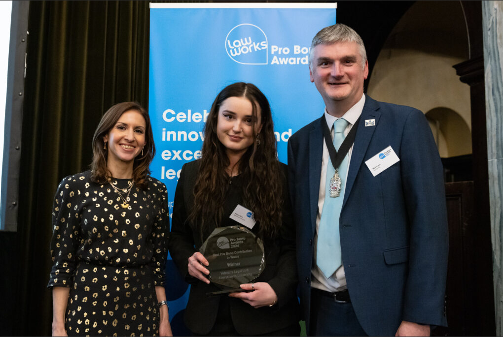 Veterans Legal Link case worker Megan Perrins (centre) accepting the award on behalf of the team at the award ceremony in London on 4 December 2024, with event host and political commentator Tamara Cohen and Vice President of the Law Society of England and Wales, Mark Evans. 