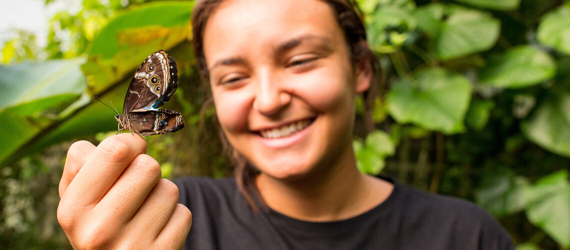 Student holding a butterfly 