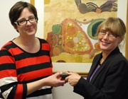 Dr Judith Broady-Preston, Director of Research and Senior Lecturer at the Department of Information Studies (right) presents the digitised version of the Open Access journal, Journal of Educational, Media and Library Services to Rebecca Davies, Pro Vice-Chancellor at Aberystwyth University.