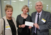 John Lewis (right), son of Rhys Lewis, and Ms Brenda Dobney (left) presenting a cheque for £10,000 to Professor April McMahon