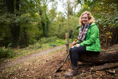 Graduate Lizzie Tyson plants the lime tree donated by her parents to Parc Natur Penglais to mark her happy years in the town as a student at Aberystwyth University.