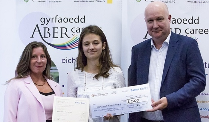 Aleksandra Kucharska (centre) receiving the Aber Forward Outstanding Achievement Award along with a cheque for £500 from David Blanchard, Balfour Beatty Investment Director, and Sian Furlong-Davies, Director of Careers Service at Aberystwyth University.