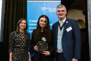 Veterans Legal Link case worker Megan Perrins (centre) accepting the award on behalf of the team at the award ceremony in London on 4 December 2024, with event host and political commentator Tamara Cohen and Vice President of the Law Society of England and Wales, Mark Evans. 