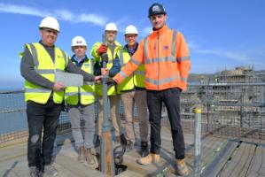 Marking the placing of the final slate on the turrets of South Seddon of Old College, 5 March 2025. Left to right; Jon Greenough (Greenough & Sons); Neil Cains (Andrew Scott Ltd); Matthew Dyer (Austin Smith Lord), Jim O’Rourke (Aberystwyth University) and Calum Duncan (Andrew Scott) stand next to the new finial on the main South Seddon turret of Aberystwyth University’s Old College.
Copyright Andrew Scott Ltd
