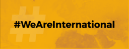 Hashtag for we are international in black text on a gold background