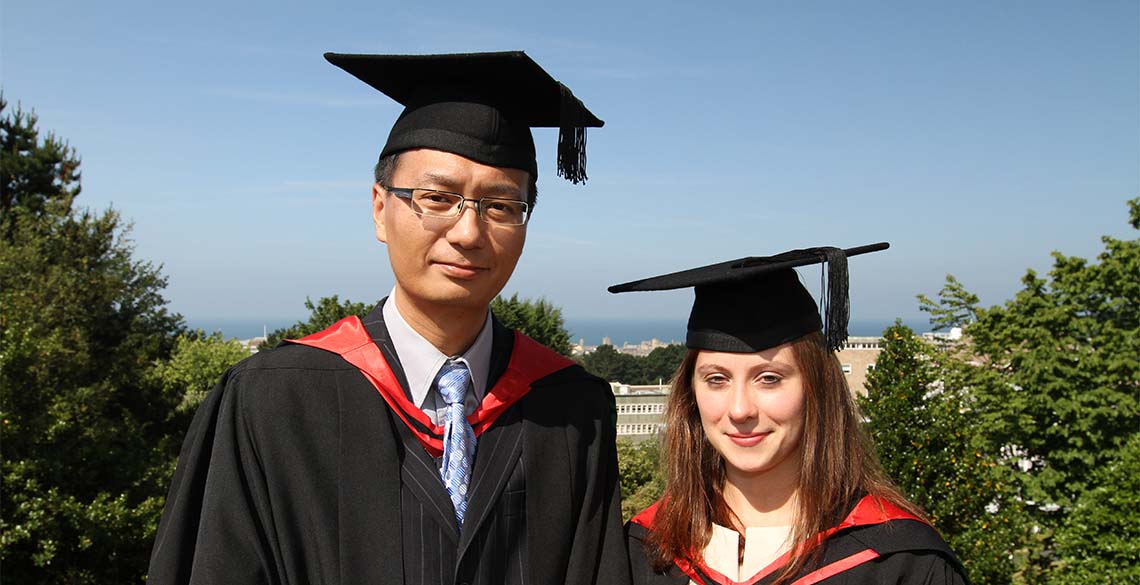 BA, BSc, MA, MSc, PhD - what do they all mean? Two Masters' students at graduation.