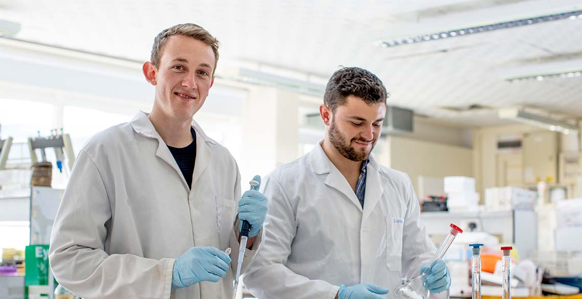 Why go to university? Two male students researching in a science lab