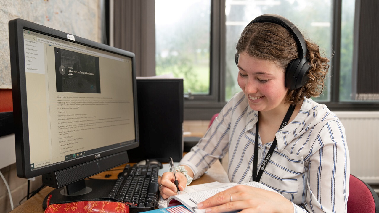 Student on computer wearing headphones