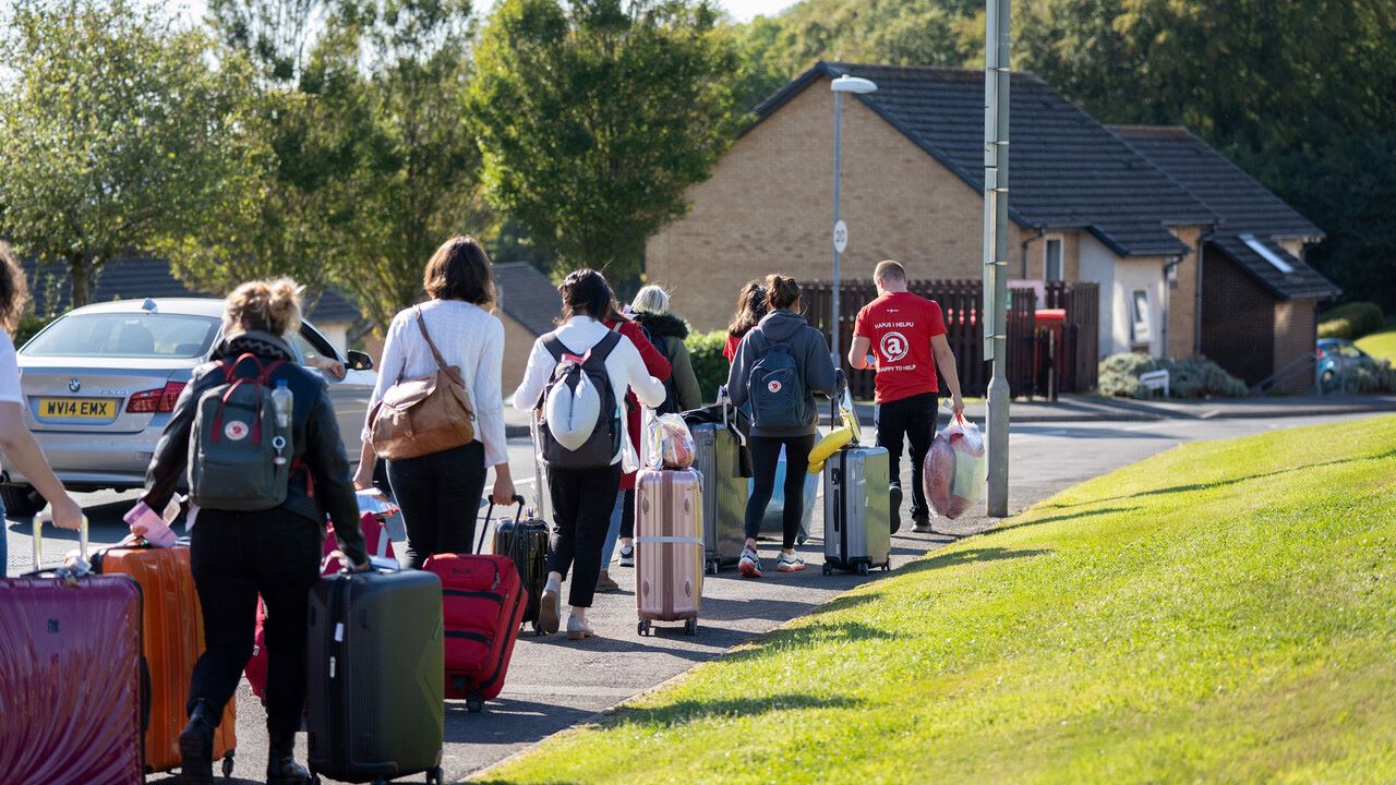 Students walking with cases to accommodation